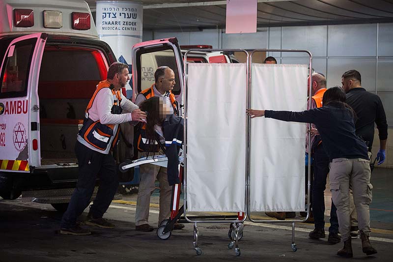 Israeli security and medical personnel remove a pregnant Israeli woman seriously injured in a terror attack in Ofra from an ambulance at the Shaarei Tzedek Hospital in Jerusalem, December 9, 2018. 